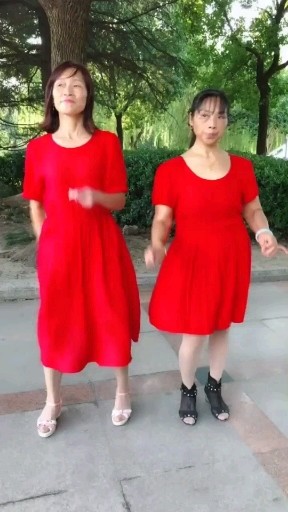 两红色连衣裙美女在华新公园嗨摇